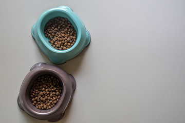 top view of cat food in blue and brown bowls