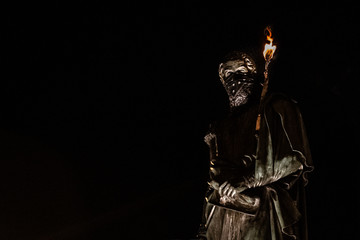 Estatua de Simón Bolívar con antifaz y antorcha en el brazo en una protesta social