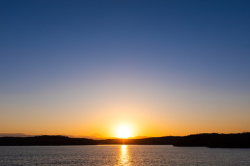 快晴の空の下に沈む夕日、狭山湖