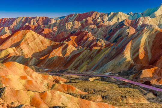 Amazing scenery of Rainbow mountain and blue sky background in sunset. Zhangye Danxia National Geopark, Gansu, China. Colorful landscape, rainbow hills, unusual colored rocks, sandstone erosion
