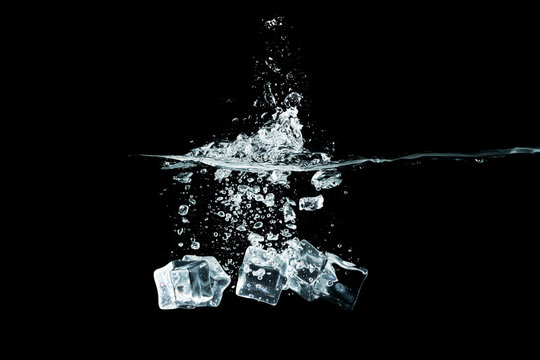 ice cubes drop to water, isolated with black background