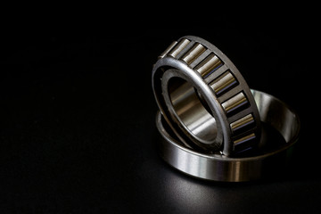 Closeup of Tapered roller bearing with copy space for your text. Spare part of mechanical on the black background..
