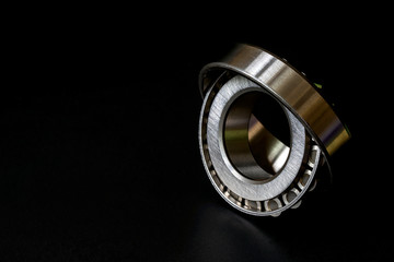 Tapered roller bearing with copy space for your text. Spare part of mechanical on black background..