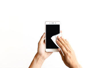 Woman hand cleaning smartphone with disinfectant wet wipe on white background. Concept of...