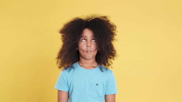 Humorous or Comical Face of Little African American Girl with Curly Hair. Funny and Idiotic Facial Expressions. Imagine Fish Face. Charismatic and Artistic Kid Have Fun and Shows Grimaces.