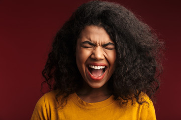 Screaming young african woman posing isolated