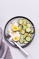 Easy vegetarian salad with cucumber, onion and eggs with vinaigrette sauce. Healthy nutrition. Selective focus