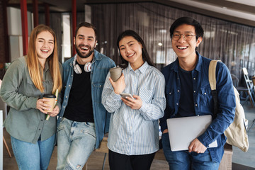 Photo of multinational cheerful students laughing and looking at camera