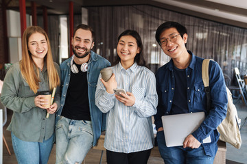 Photo of multinational cheerful students laughing and looking at camera