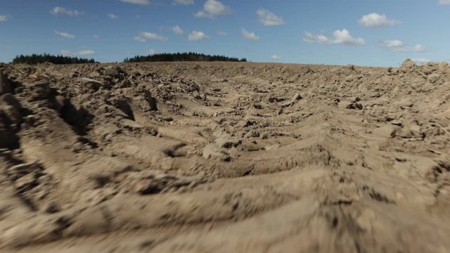 Video 4k, the texture of the earth plowed by a tractor, looks like a moon landscape, background for design