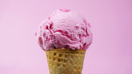 Ice cream flavoured Strawberry scooped in waffle cone on pink background, Closeup Front view Food concept.