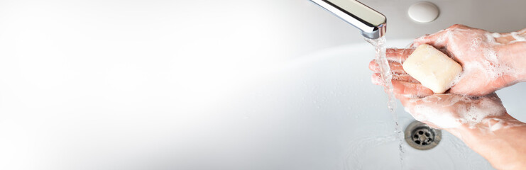 Washing hands with soap under the faucet with water in bathroom for coronavirus germs spreading...