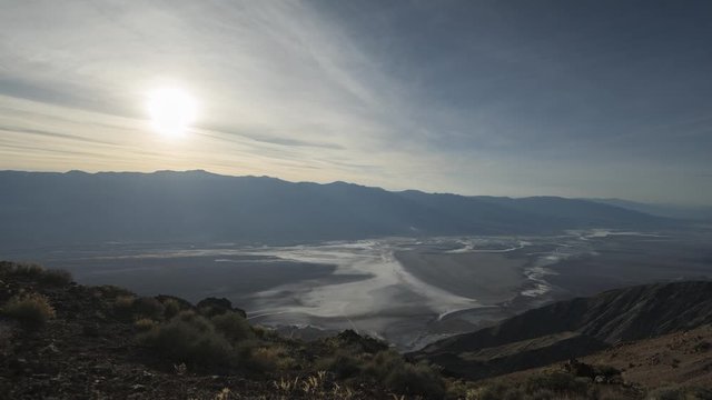 A wide timelapse of sunset over the Panamint Range with a hazy Death Valley below, as seen from high up in Dante's View.