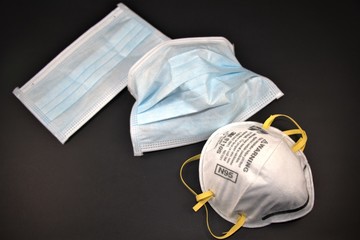Medical surgical masks and N95  Respirator. Closeup photo against black background. Personal Protective Equipment or PPE.