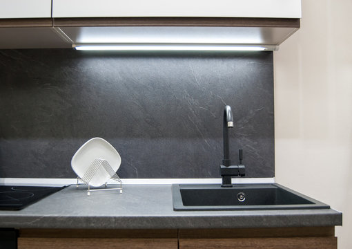 Dark Gray Laminate Worktop With Black Faux Stone Sink With Faucet In A Modern Kitchen