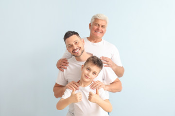 Fototapeta na wymiar Man with his father and son on color background