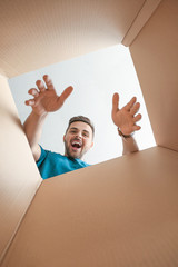 Happy man with open box, view from inside