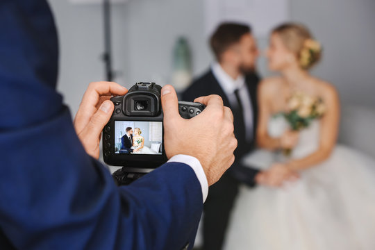 Photographer working with young wedding couple in studio, closeup
