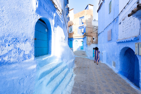 A traditional dressed moroccan woman walks in the old town (medina) of Chefchaouen in Morocco.. Social concept.