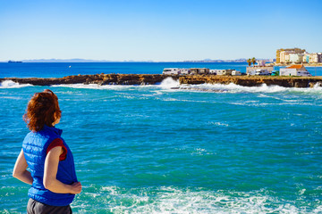 Tourist woman on sea cliffs in Spain
