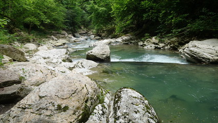 Naklejka na ściany i meble The river in the gorge runs over the stones