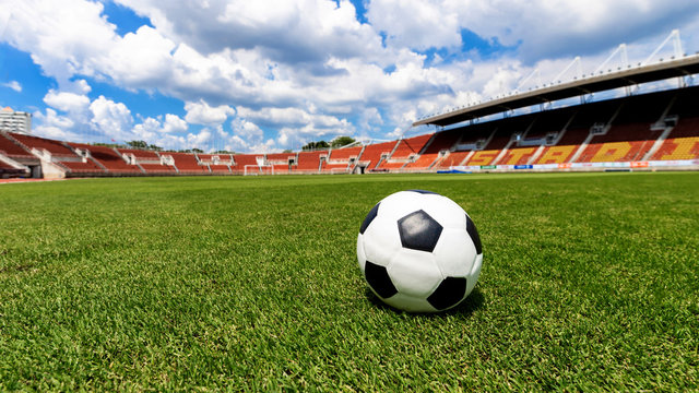 football field  ball on green grass , soccer field athletics stadium and blue sky background