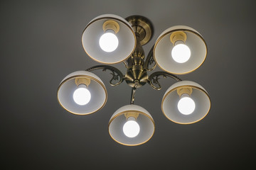 a 5-light chandelier hangs on the white ceiling