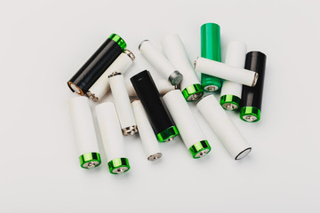 Naklejka premium many new and used alkaline the positive ends of battery cells. type AA on a light background.