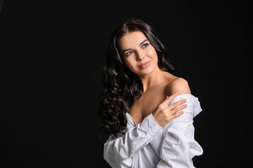 Young woman with beautiful healthy hair on dark background