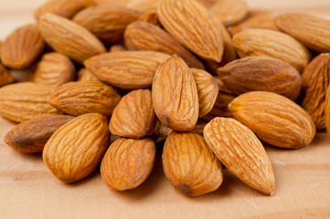 Almonds nuts shot large on a wooden background. Background for healthy eating and vegetarianism.