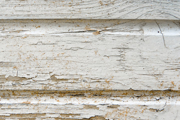 Texture wood wall with old cracked weathered white paint closeup with cracks and scratches smeared with sand. Abstract background for your design with copy space and place for text