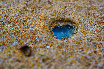 blue crystal in the sand closeup