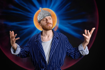 mysterious man in foil cap with nimbus and hands up