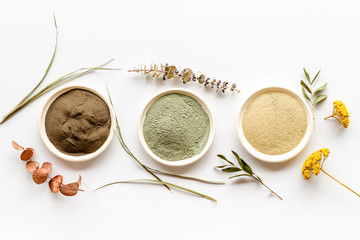Clays set for face mask on white table top-down flat lay