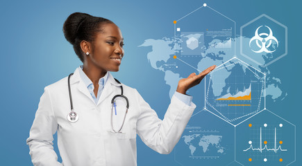 medicine, profession and healthcare concept - happy smiling african american female doctor in white coat with stethoscope showing world map with charts and biohazard symbol on blue background