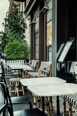 Street cafe with empty tables on a cloudy day. Close-up. Vertical.