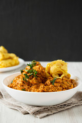 Homemade Chicken Tikka Masala in a white bowl, side view. Close-up.