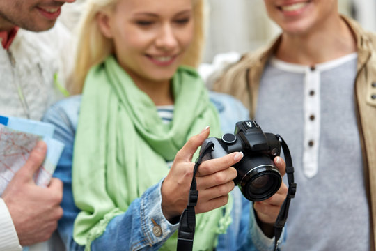 travel, photography, technology and friendship concept - close up of happy smiling friends with digital camera