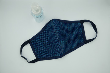 Blue indigo woven fabric cloth face mask and ethyl alcohol For covid19 virus protection, isolated on a white background.Mask made from woven fabric cotton for wearing to protect against Coronavirus.