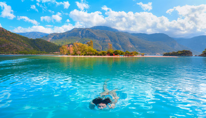 Young girl swimming in Blue Lagoon of Oludeniz next to Mediterranean sea - Fethiye, Turkey