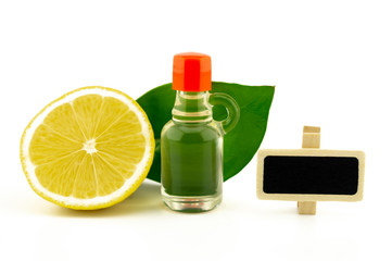 Lemon with green leaves alongside a glass decanter
