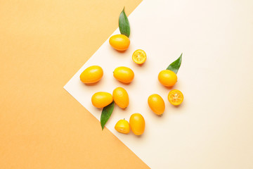 Tasty kumquat fruit on color background