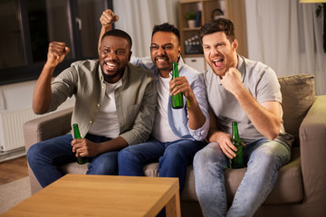 friendship, emotions and leisure concept - happy smiling male friends or fans drinking beer at home