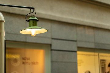 Edison bulb lamp hanging in front of the window with old town behind.