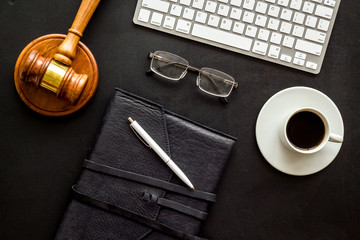 Law student office flat lay with judge hammer, keyboeard, notebook. Black, top-down