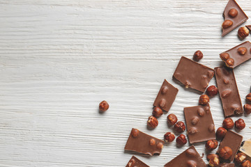 Sweet chocolate with nuts on white wooden table