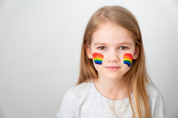 small girl painted cheeks a rainbow. stay home. 