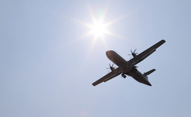 Closeup of an airplane landing to the destination airport with sunny sky background.