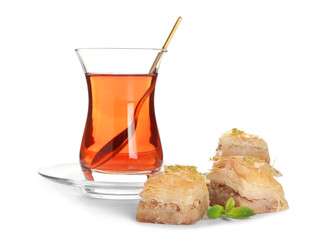 Tasty Turkish tea with sweets on white background