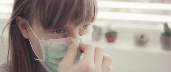 Woman put on surgical face mask staying home during coronavirus covid 19 virus outbreak close up - Powered by Adobe